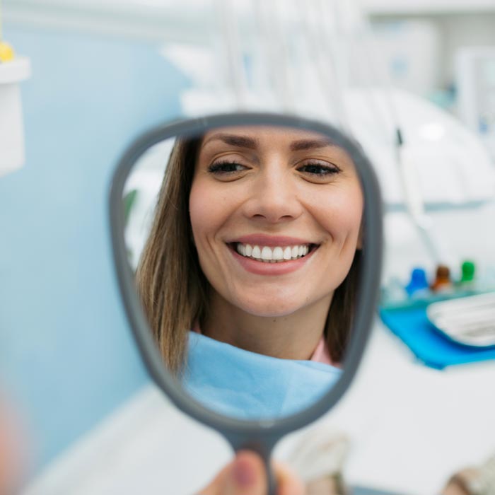 woman looking at smile in mirror