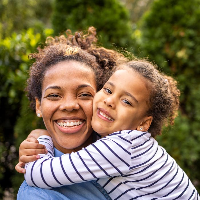 mother and young daughter smiling